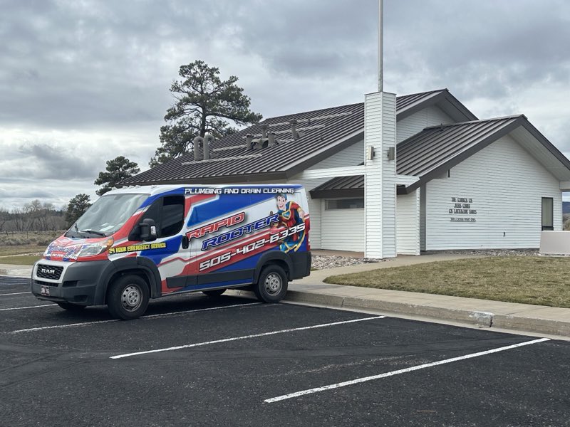 A wrapped Rapid Rooter ProMaster van parked at a job site, reading Plumbing and Drain Cleaning and 24 Hour Emergency Service.